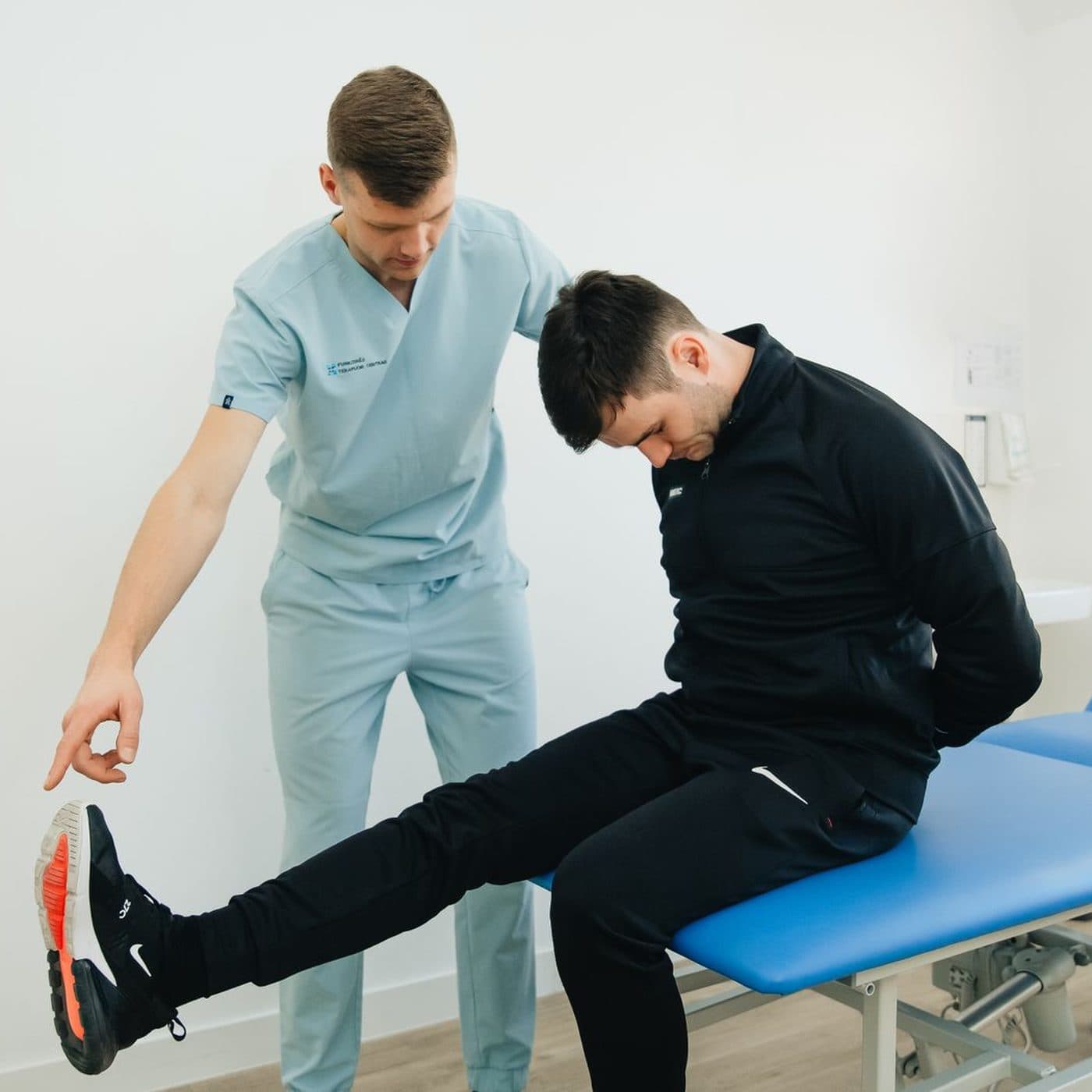 Physiotherapist assessing an athlete's knee during a treatment session
